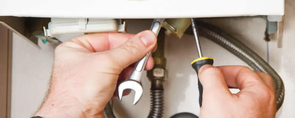 Boiler repair technician tightening pipe fittings and connections in Sarasota, FL