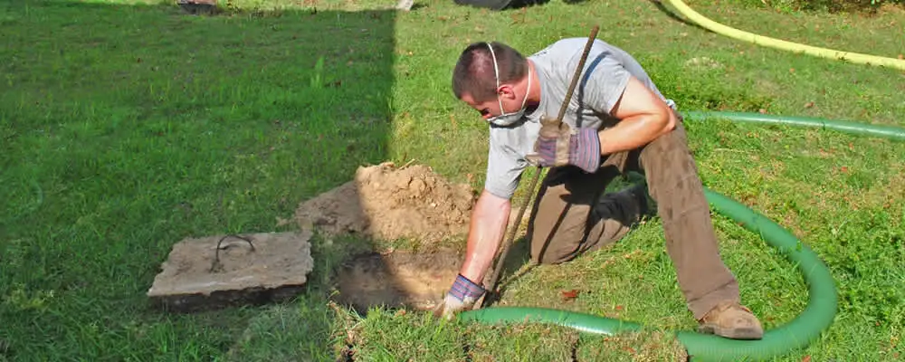 Septic pumping technician servicing a residential septic tank in Sarasota, FL