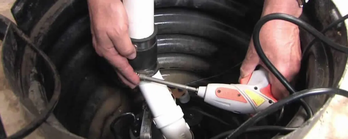 Sump pump installation technician connecting PVC discharge piping in Sarasota, FL